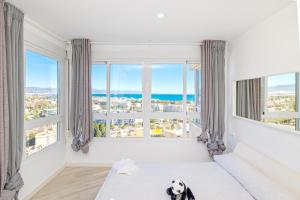 Pokój z dużymi oknami z psem siedzącym na podłodze w obiekcie Sun Apartments w mieście Torremolinos