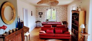 a living room with a red couch and a mirror at Propriété avec piscine de 2 à 9 personnes, Gîte De Saint Donat, in La Roque-Gageac