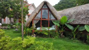 uma pequena casa com telhado de palha em JoyStay em Ilha de Cát Bà