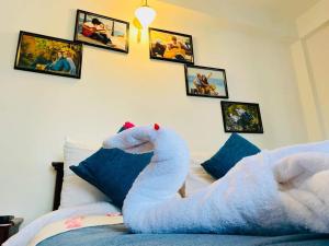 a large white stuffed animal laying on a bed at Thilina Hotel in Nuwara Eliya