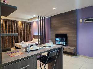 ein Hotelzimmer mit einer Küche und einem Schlafzimmer in der Unterkunft Regalia Comfort Suites KLCC SkyPool in Kuala Lumpur