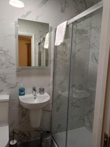 a white bathroom with a sink and a shower at Prestige in Cambridge