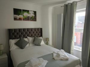 1 dormitorio con 1 cama con 2 toallas en Prestige, en Cambridge