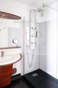een badkamer met een douche en een wastafel bij Kyriad Prestige Les Sables d'Olonne - Plage - Centre des Congrès in Les Sables-dʼOlonne