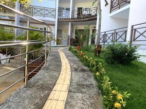 a walkway in front of a building with flowers at Apartamento moderno e totalmente acessível in Pipa