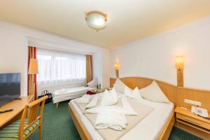 Habitación de hotel con cama con almohadas blancas en Der Schütthof, en Zell am See