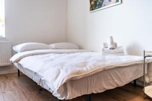ein Schlafzimmer mit einem Bett mit einer weißen Tagesdecke in der Unterkunft Będzin Standard Apartment in Będzin