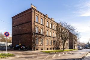 ein altes Backsteingebäude an der Straßenseite in der Unterkunft Będzin Standard Apartment in Będzin