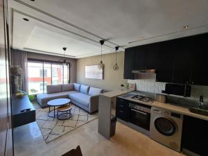 a kitchen and living room with a couch and a table at Studio Cosy Haut Standing in Casablanca