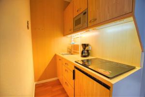 - une petite cuisine avec des placards en bois et un comptoir dans l'établissement Ferienpark - Haus G, App 0G0305, à Heiligenhafen