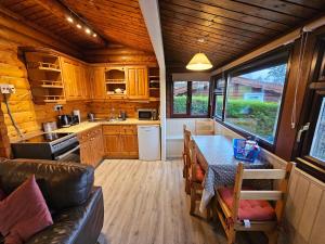 een keuken met houten kasten en een tafel in een tiny house bij Cosy 2 bedroom Log Cabin in Snowdonia Cabin151 in Trawsfynydd