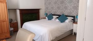 a bedroom with a large white bed with blue pillows at Riverdale Hall Hotel & Leisure in Bellingham