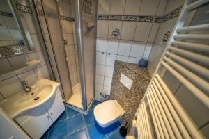 La salle de bains est pourvue d'un lavabo, de toilettes et d'une douche. dans l'établissement Ferienpark - Haus G, App 0G0602, à Heiligenhafen
