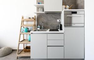 a white kitchen with a sink and a ladder at Gallery Luxury Suites & Rooms-Only Adults in Split