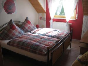1 cama con manta a cuadros y almohadas en un dormitorio en Ferienwohnung 'am Bienwald', en Schaidt