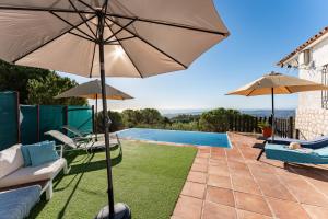 un patio con ombrelloni e una piscina di Villa Fenavista a Mijas
