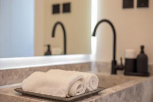 un bancone del bagno con un lavandino con due asciugamani su un vassoio di Amber Hospitality - Qurtubah a Riyad Altre 101 foto