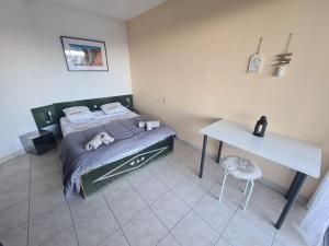 Schlafzimmer mit einem Bett und einem weißen Tisch in der Unterkunft LA NAPOULE in Mandelieu-la-Napoule