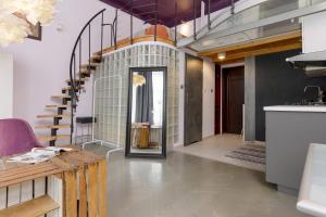 a hallway with a spiral staircase in a house at Artist's Dream Studio with Mezzanine by Renters in Warsaw