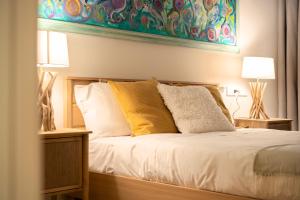 a bed with two lamps and a painting on the wall at Santa Tecla Living Washington Building in Milan
