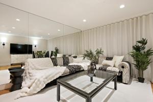 ein Wohnzimmer mit einem Sofa und einem Glastisch in der Unterkunft Hububb Luxury Apartment Kensington in London