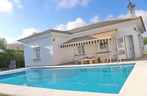a villa with a swimming pool in front of a house at Chalet Cocle in Novo Sancti Petri