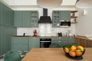 a kitchen with green cabinets and a bowl of fruit on a table at Santa Tecla Living Washington Building in Milan