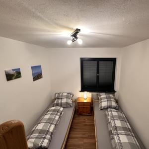 ゾントホーフェンにあるFeWo Schwäbeleholz mit 2 Schlafzimmernのベッドが2つと壁にテレビがある部屋