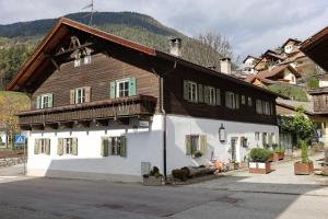 a large white and brown building with a wooden roof at Tulpe Apartments in Vandoies di Sotto