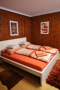 a bed in a room with wood paneling at Tulpe Apartments in Vandoies di Sotto
