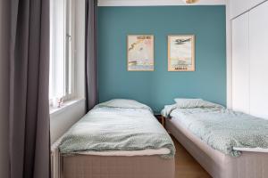 2 camas individuais num quarto com paredes azuis em A new apartment in Helsinki em Helsinque