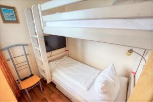 - une chambre avec 2 lits superposés et une chaise dans l'établissement Ferienpark - Haus G, App 0G1108, à Heiligenhafen