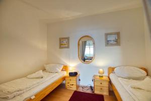 2 Betten in einem Zimmer mit Spiegel in der Unterkunft Ferienpark - Haus G, App 0G1003 in Heiligenhafen