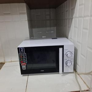 a microwave oven sitting on top of a counter at Dolphin-holiday homes mombasa in Ndome