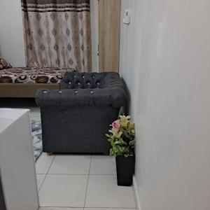 ein Wohnzimmer mit einem Sofa und einer Vase mit Blumen in der Unterkunft Dolphin-holiday homes mombasa in Ndome