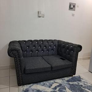 a black couch sitting in a room with a rug at Dolphin-holiday homes mombasa in Ndome