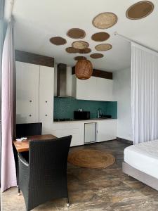 sypialnia ze stołem i łóżkiem oraz kuchnia w obiekcie Suite by the Pool w mieście Faaa