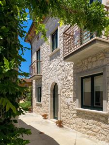 a stone house with a balcony on a street at Casa Rurale Faraone in Teggiano