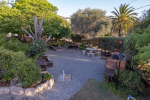a garden with benches and tables and trees at Descanso las Tres Marias Apart Hotel in Villa Carlos Paz