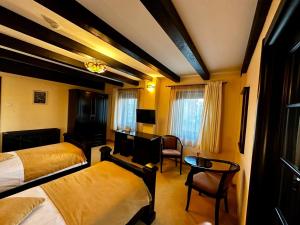 Podu' cu Lanturi في باكاو: غرفة فندقية بسريرين وطاولة وكراسي