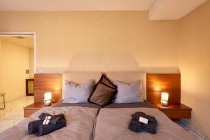 ein Schlafzimmer mit einem Bett mit zwei Taschen darauf in der Unterkunft Vienna Prestige Central Luxury Haven w Free Parking and SAUNA in Wien