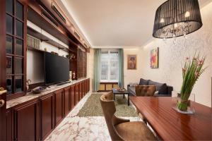 a living room with a table and a television at Vienna Prestige Central Luxury Haven w Free Parking and SAUNA in Vienna