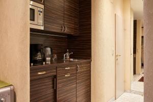 a kitchen with wooden cabinets and a microwave at Vienna Prestige Central Luxury Haven w Free Parking and SAUNA in Vienna