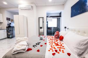Un dormitorio con una cama con corazones rojos. en SUITE SPACE by concept italy, en Casoria
