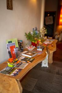 una mesa de madera con libros y revistas. en Garnì Tuttotondo en Levico Terme