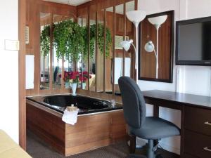 a office with a desk and a chair and a tub at Country Squire Motel in Arnprior