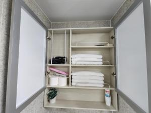ein Schrank mit weißen Handtüchern und Handtüchern in der Unterkunft Sokcho Summitbay 1209 "Ocean View" in Sokcho