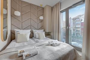 a bedroom with a bed and a large window at Waterlane Riverside SPA, Pool & Gym by Downtown Apartments in Gdańsk