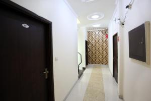 un pasillo con una puerta negra y un televisor en OYO Hotel Rich Inn, en Amritsar