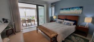 1 dormitorio con 1 cama grande y balcón en Beachwalk Deluxe Apartment - 50 steps to the beach, en Cap Malheureux